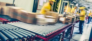 $5 parcel tax: warehouse workers sorting packages on conveyor belt